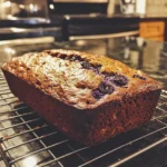 Blueberry Zucchini Bread Recipe – Moist & Irresistible 7 Blueberry zucchini bread loaf cooling on a wire rack in a kitchen