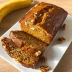 Best Pumpkin Banana Bread – Ultimate Cozy Fall Recipe 6 Sliced pumpkin banana bread loaf with walnuts on white plate