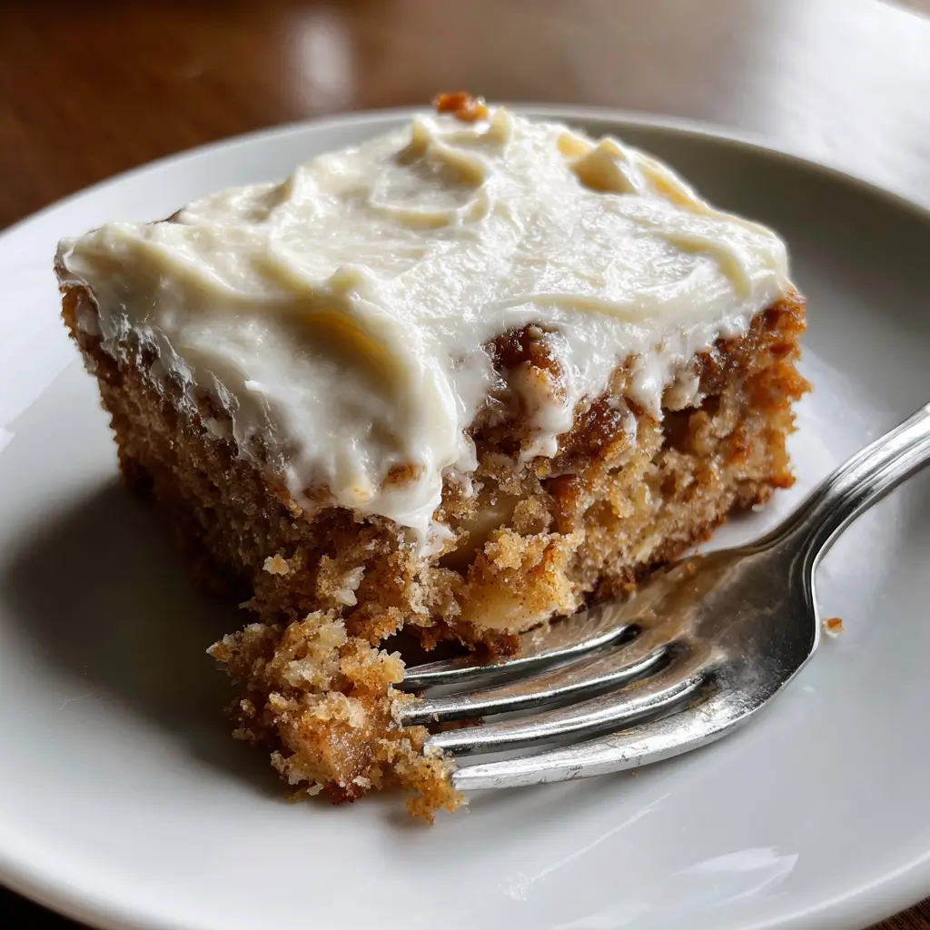 Slice of 3-Ingredient Apple Cake with cinnamon frosting on a white plate