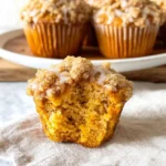 Pumpkin streusel muffins with crumb topping and moist interior on rustic wooden table – pumpkin muffins, pumpkin crumb muffins